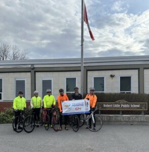 Marc Clare, HLF CEO and five other riders holding a banner for HLF Month as part of their Tour De Halton.