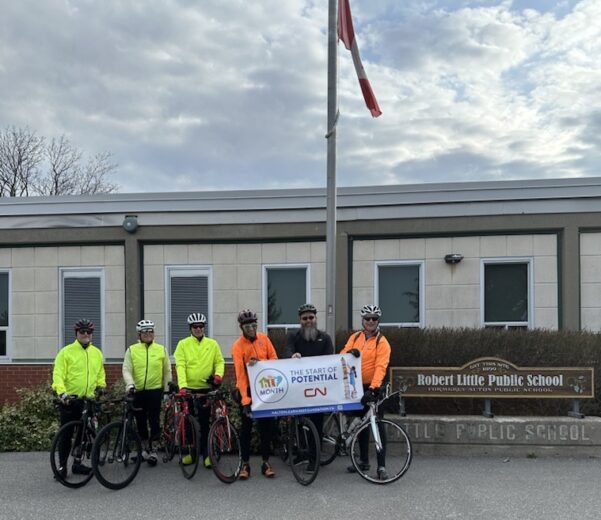 Marc Clare, HLF CEO and five other riders holding a banner for HLF Month as part of their Tour De Halton.