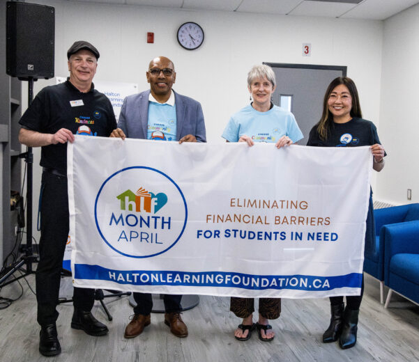 the image shows HDSB and HLF leadership team carrying a flag to launch HLF Month to help students in need.