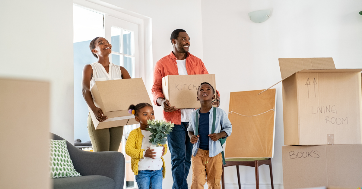A joyful family moves into a new home, carrying labeled boxes. The parents smile, while two children, one with flowers, explore the bright, cozy room.